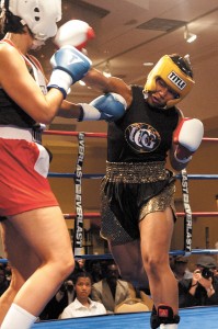 Buckhead accountant Lori Williams-Jones, right, throws a punch during a boxing match.