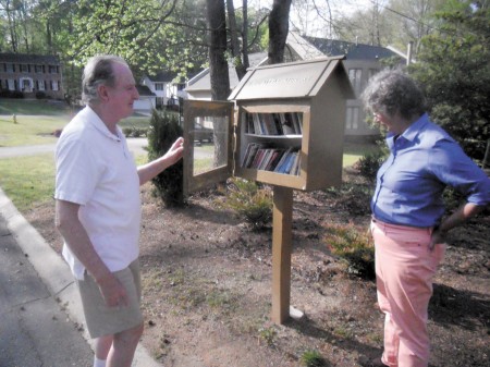 Ronald Pennington, left, and his wife, Joan Warren, with their bookbox on Martina Drive.