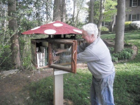 G. Michael Smith checks on his mushroom-shaped ‘little library’ on Witham Drive in Dunwoody.