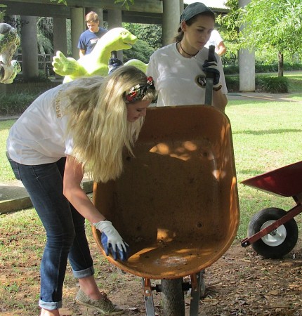 Mount Vernon 11th-grader Emily Hollis (left) and 12th-grader Arden Tahtinen empty mulch from a wheelbarrow.