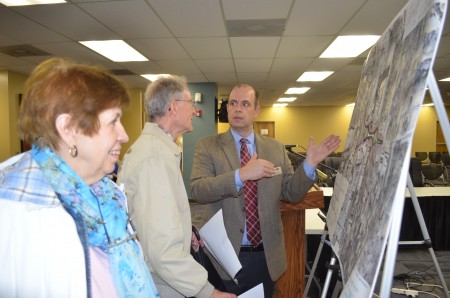 Ellyn Musser, left, and Don Houze, center, discuss the roundabout plan with project manager Ryan Trick of Jacobs. 
