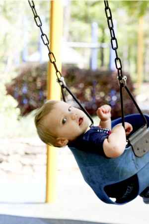 Brooks Rosencrans, 1, enjoys being pushed in a swing at Brook Run Park's playground. Photo by Ellen Eldridge