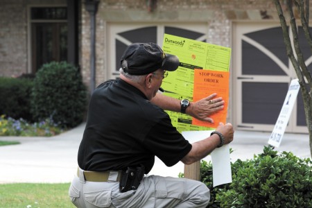 Dunwoody Code Compliance Officer Tom LaPenna places a stop work order at a residence. Photo by Ellen Eldridge.