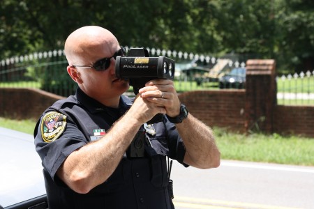 Dunwoody Officer Chris Irwin checks speeds with a radar detector July 16 along Tilly Mill Road. A total of 12 citations and three warnings were issued to drivers during a pedestrian safety detail. Photo by Ellen Eldridge