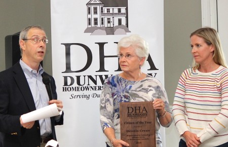 Dunwoody HOA President Robert Wittenstein presents Marie Crean and her daughter a plaque honoring Dennis Crean as Citizen of the Year. (Photo Dyana Bagby)