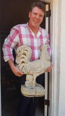 Dr. Robin Fowler holding one of the rooster statues he rescued, and which may have once stood on a lost front gate at the Thornton House. (Photo John Ruch)