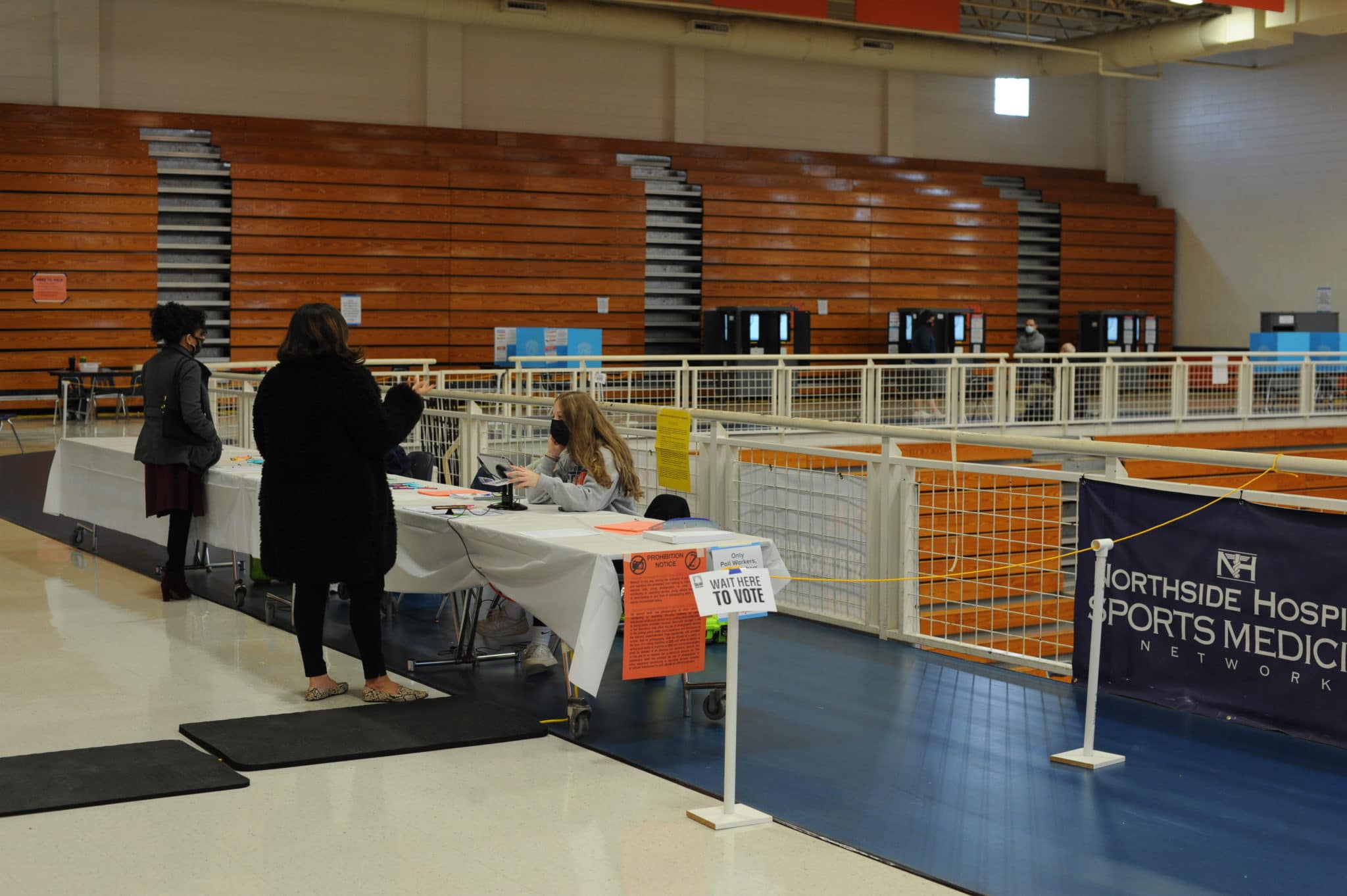 Poll workers assist voters at the gym at North Springs High School in Sandy Springs.
