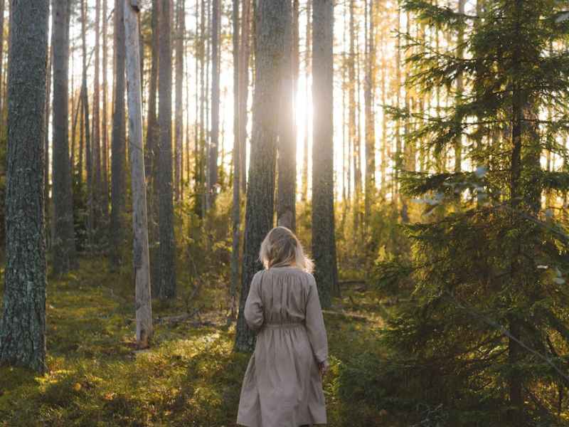 woman wearing a coat walking in the forest
