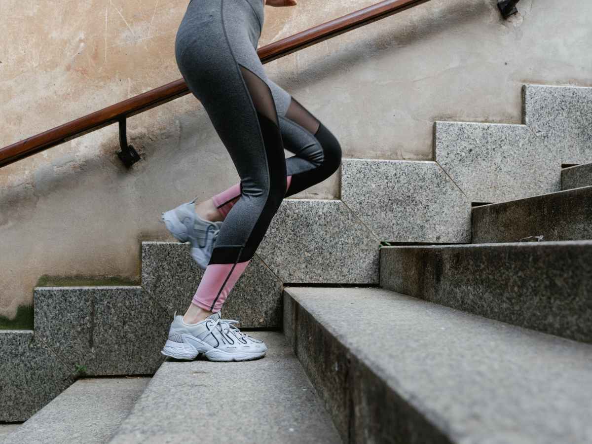 a person in black and pink leggings climbing the concrete stairs