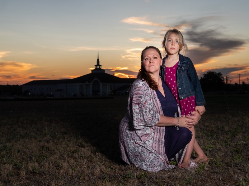 "Mama Bear" Kimberly Shappley and her daughter Kai outside of a church at sunset.
