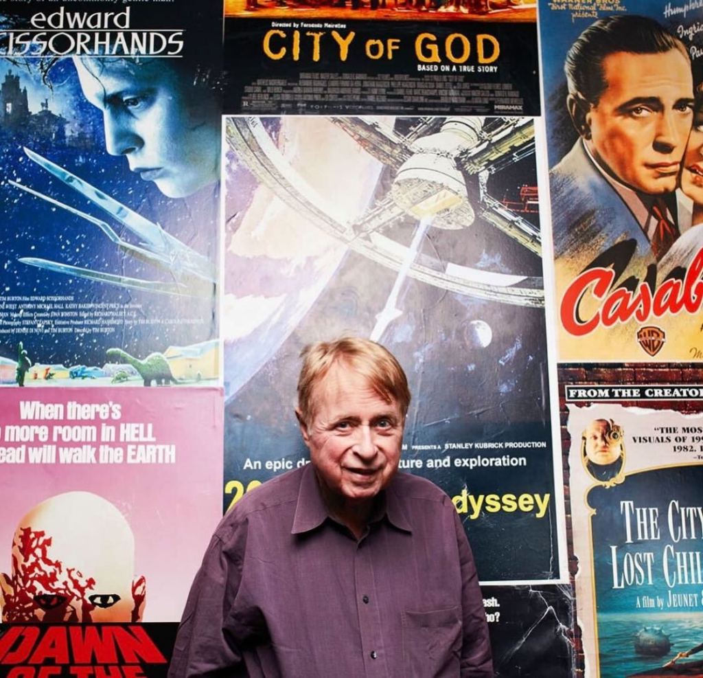 George Lefont standing in front of vintage movie posters. 