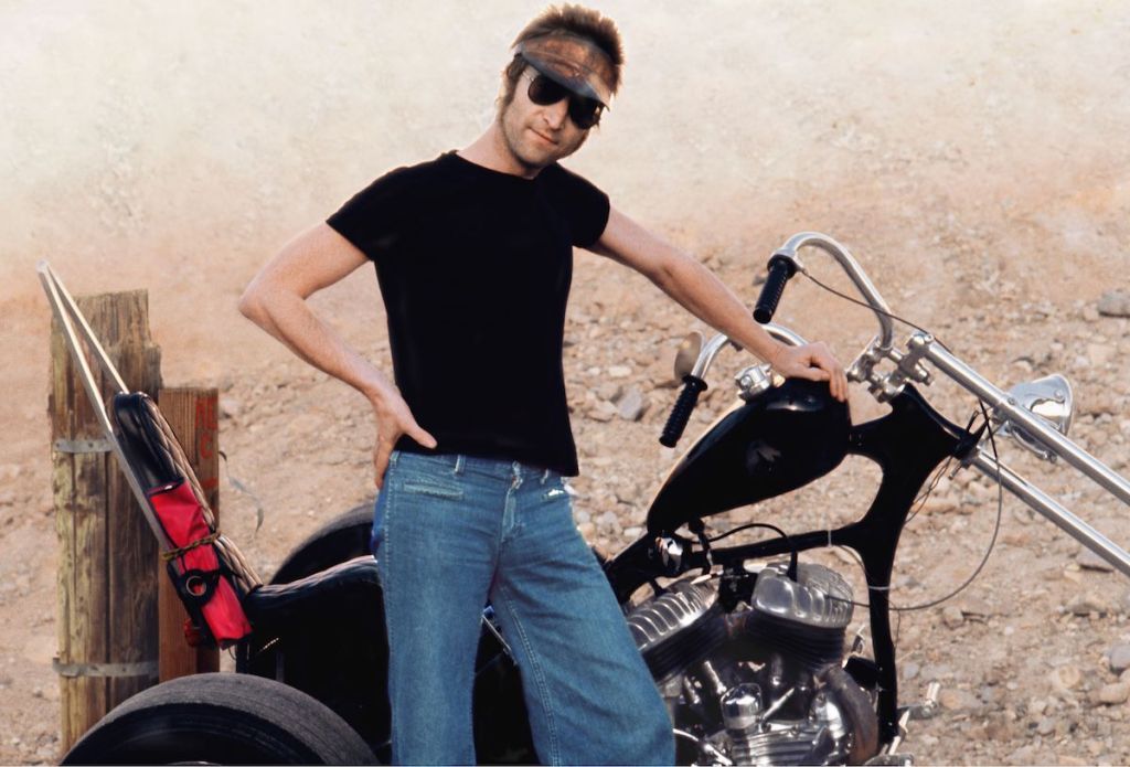 John Lennon poses with a motorcycle (May Pang). 